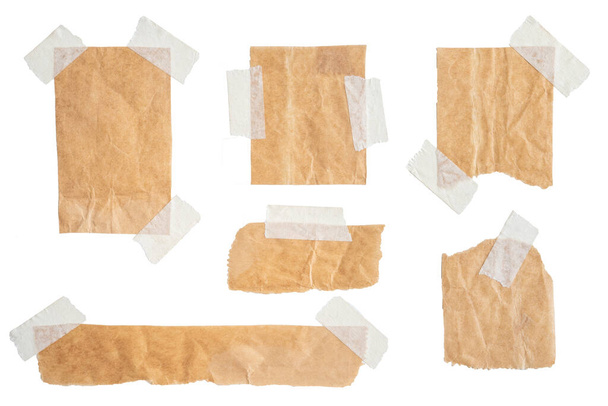 Braune Papieretiketten mit Klebeband auf weißem Hintergrund befestigt - Foto, Bild