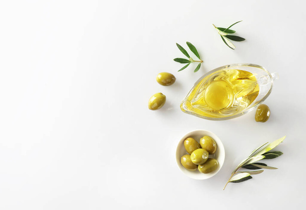 Olive branch and olive oil isolated on white background. Top view - Φωτογραφία, εικόνα