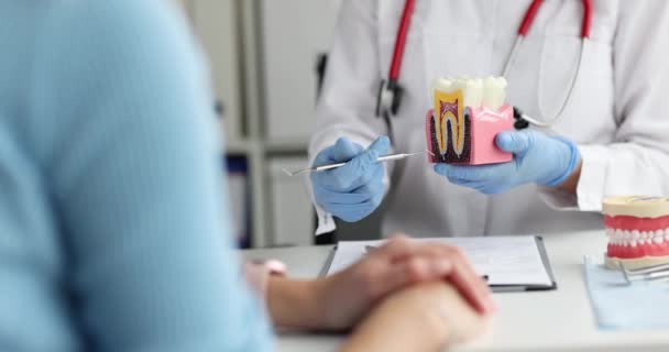 Lekarz dentysta pokazuje model stomatologiczny z próchnicą do pacjenta 4k film - Materiał filmowy, wideo