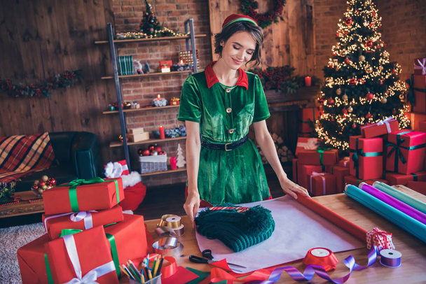 Photo of young cheerful positive santa helper woman make present wrap assistant indoors inside house home - Photo, image