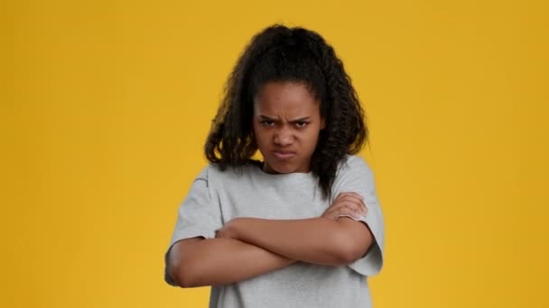 Niezadowolona Afroamerykanka nastolatek dziewczyna Crossing ręce na żółtym tle - Materiał filmowy, wideo