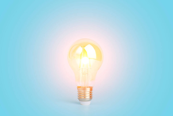 Osaamisen ja idean käsite. Lamppu, jossa on valoa tyhjällä sinisellä taustalla. Aivot, viisaus, tieto ja energiansäästö on luova idea. - Valokuva, kuva