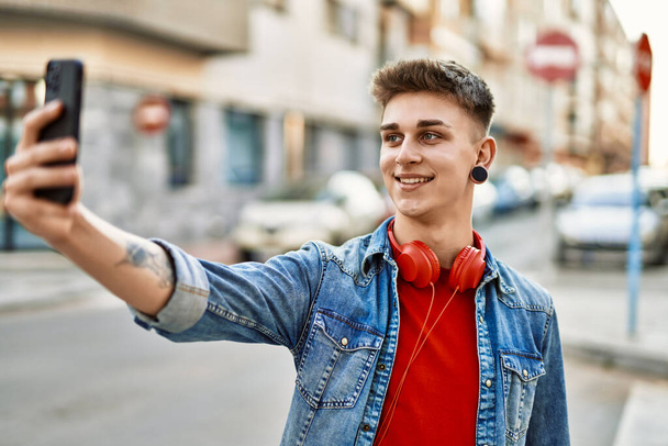 Jeune caucasien gars souriant prendre une photo selfie à la ville - Photo, image
