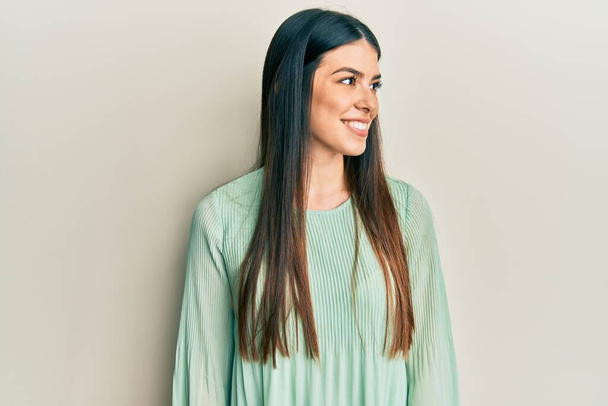Mulher hispânica jovem vestindo roupas casuais olhando para o lado, relaxe pose perfil com rosto natural e sorriso confiante.  - Foto, Imagem