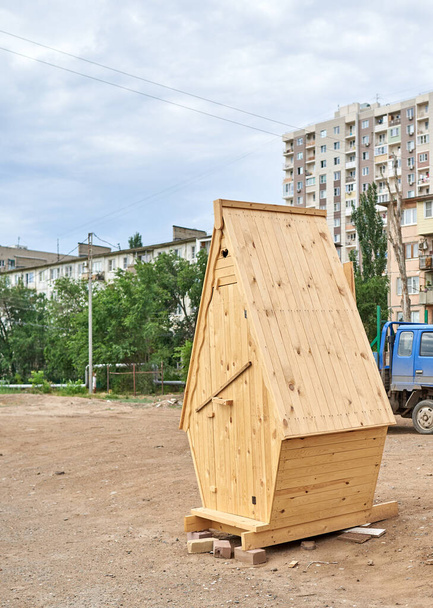 Un inodoro de madera se encuentra en medio de una calle de la ciudad - Foto, imagen
