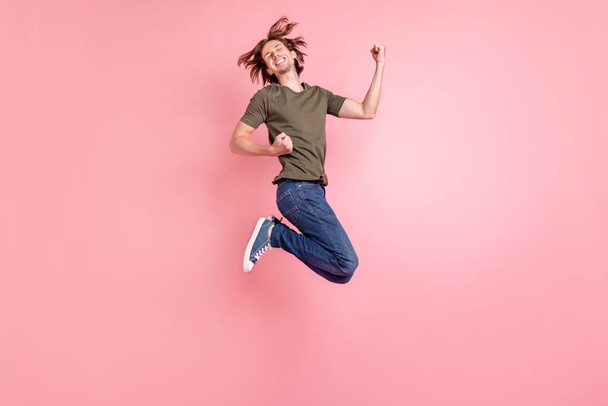 Full body profile side photo of young guy happy positive smile jump rejoice victory success isolated over pastel color background - Foto, Imagen