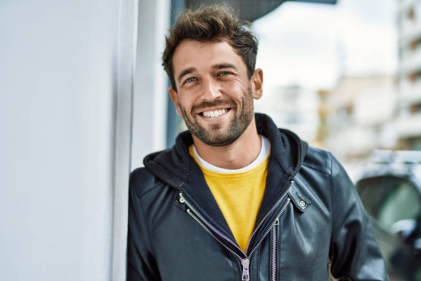 Schöner hispanischer Mann mit Bart, der im Freien glücklich lächelt - Foto, Bild