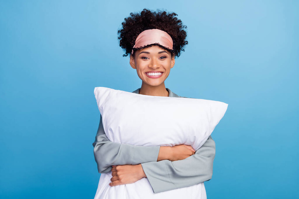 Photo of young cheerful african lady hug pillow blindfold sleepover bed isolated over blue color background - Photo, image