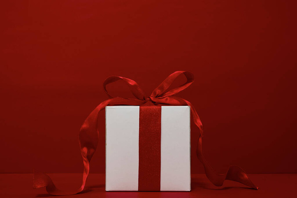 Подарункова коробка Різдво з червоною стрічкою на червоному тлі
 - Фото, зображення