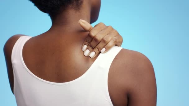 Ruumiinongelmia. Tuntematon afrikkalainen amerikkalainen nainen hieromassa olkapäätään ja kaulaansa, kärsien tulehduksesta - Materiaali, video