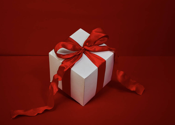 Gift box Christmas with red ribbon on red background - Photo, Image