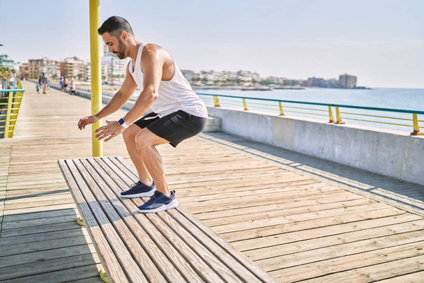 Hispanic man working out jumping a bench outdoors on a sunny day - Photo, Image