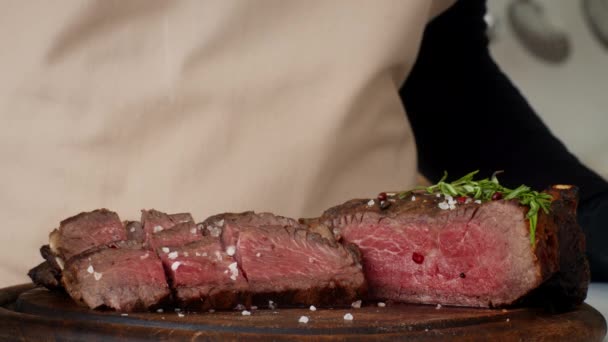 Onherkenbaar koken kruiden rundvlees steaks strooien zout in de keuken, Closeup - Video