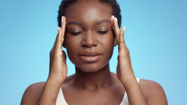 Migrén szindróma. Stúdió portré feldúlt afro-amerikai hölgy szenved fejfájás támadás, masszírozó templomok - Felvétel, videó