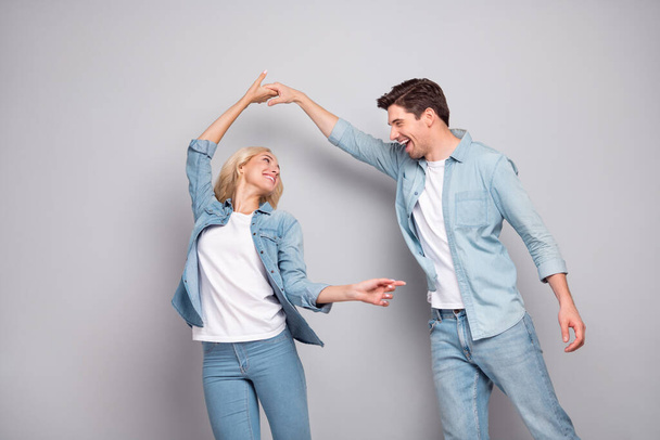 Portrait of attractive cheerful couple dancing having fun pastime isolated over grey pastel color background - Foto, Imagen