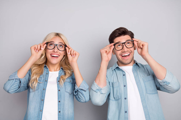 Photo of young couple happy positive smile hands touch eyeglasses vision look empty space isolated over grey color background - Фото, зображення