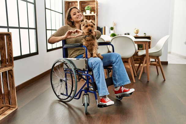 Молодая латиноамериканка, сидящая дома на инвалидной коляске, думает, что устала и ей скучно от депрессии со скрещенными руками..  - Фото, изображение