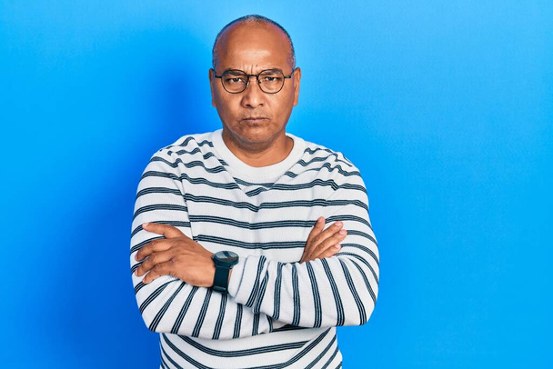 Middle age latin man wearing casual clothes and glasses skeptic and nervous, disapproving expression on face with crossed arms. negative person.  - Photo, Image