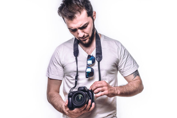Man with camera. Hipster photographer takes photo in studio. Isolated white background - Photo, Image