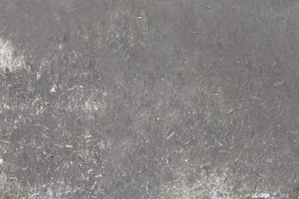 The weathered surface of the chipboard sheet, faded under the sun. Mottled structure with fine speckles. - Foto, Bild