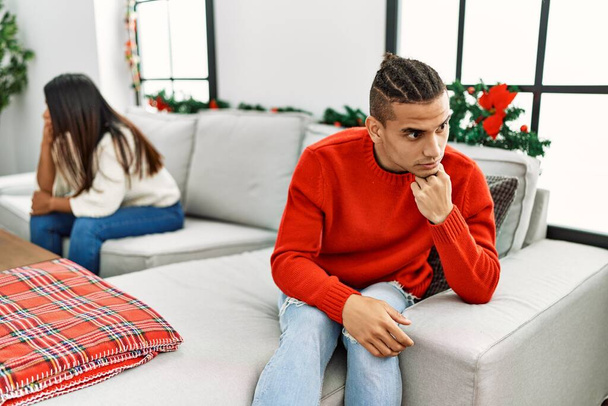 Junges lateinisches Paar über Probleme mit traurigem Gesichtsausdruck, wenn es zu Hause auf dem Sofa sitzt. - Foto, Bild