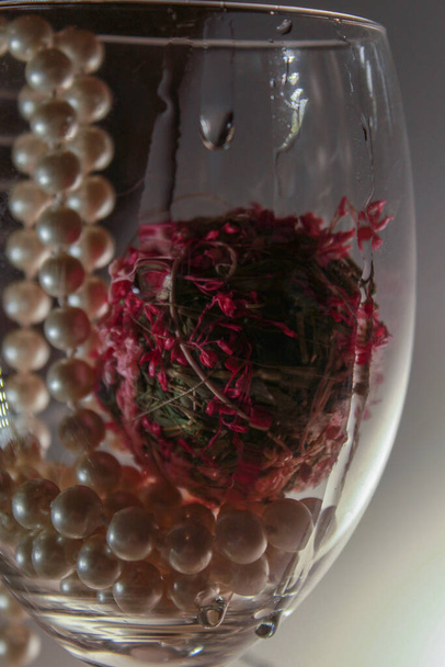 Glass with pearls and flowers inside - Foto, Imagen