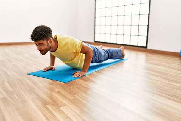 Mladý arabský sportovní muž soustředit trénink abs cvičení ve sportovním centru. - Fotografie, Obrázek