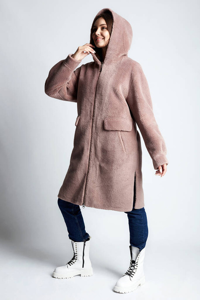 Happy young woman wearing pink fur. beautiful smilingl girl in Hoodie coat. Winter fashion - Photo, Image