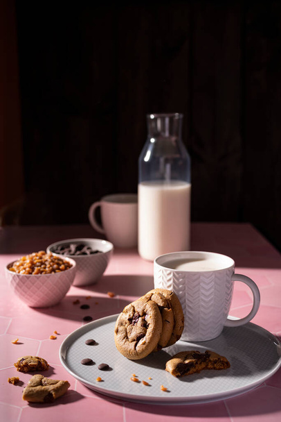 Fresh chocolate ship cookies and milk on a sunny setup - Foto, afbeelding