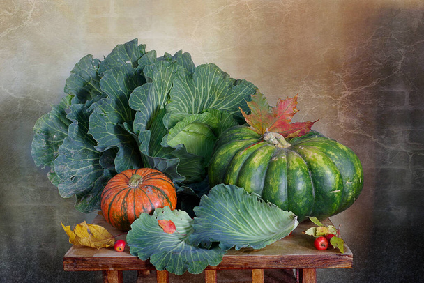 A gorgeous head of cabbage, pumpkin, autumn leaves, red apples lie beautifully on the table.Autumn background.Thanksgiving day. - Fotografie, Obrázek