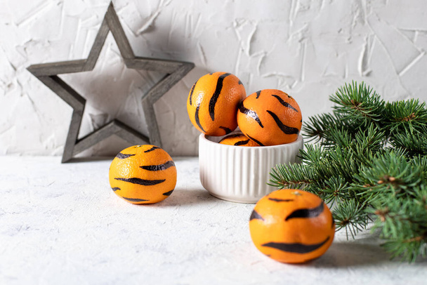 Tangerine festett csíkok fehér alapon egy karácsonyfa. A koncepció az új év a tigris a gyermekek számára. Tigris mandarin gyerekeknek szórakoztató - Fotó, kép