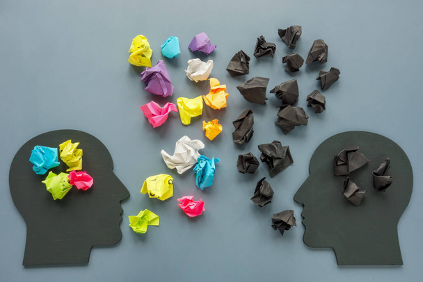 Positive and negative thinking concept. Figures of heads and paper balls. - 写真・画像