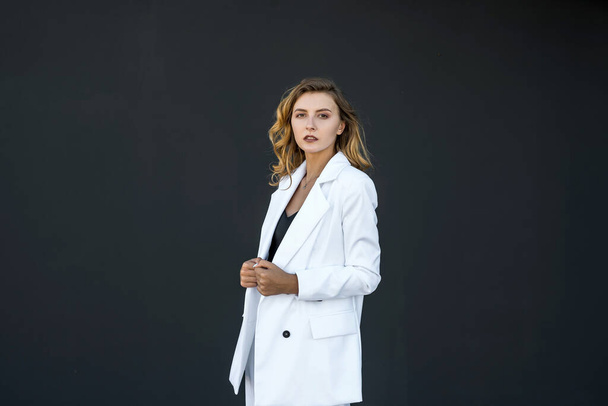 modern pretty woman in white suit isolated on black background. female portrait. - Foto, immagini