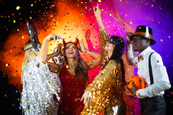 Happy people men and women mixed race dancing together on Halloween party - Foto, Imagen
