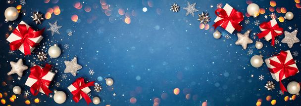 Gift Box And Christmas Ornament On Blue Snowy Background - Present With Red Ribbon And Bokeh Lights - Photo, Image