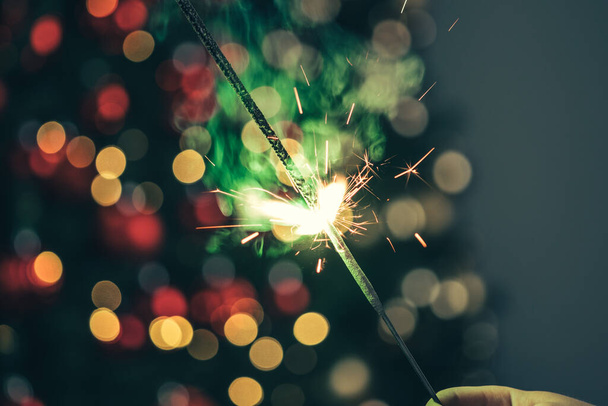 Close-up of green holiday sparkler in the dark - 写真・画像