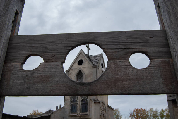 古代の教会の背景に犯罪者を罰するための中世のブロック。中世処刑兵器 - 写真・画像