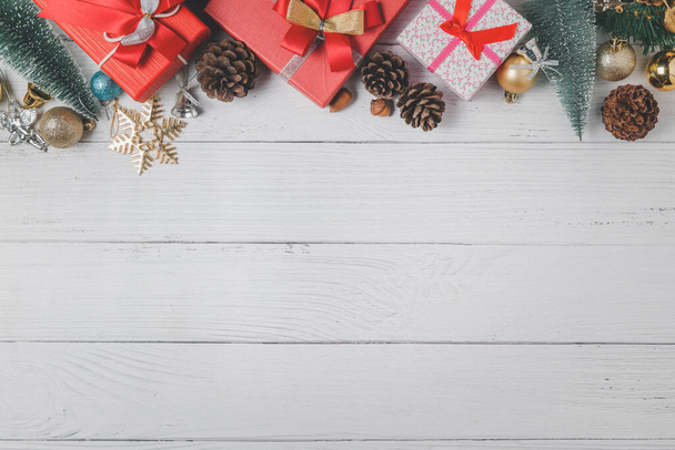 Kerst achtergrond met rood cadeau en sparren boom en decor op witte houten achtergrond. Bovenaanzicht met kopieerruimte - Foto, afbeelding
