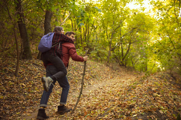 Full-length image of young couple walking on autumn forest, hiking activity - Photo, Image