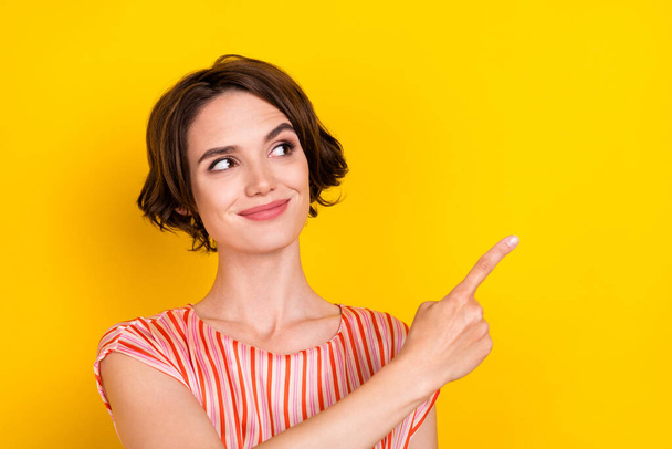 Portrait of attractive cheerful girl demonstrating copy space ad way direction isolated over bright yellow color background - Photo, Image