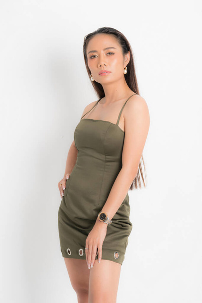 Fashion style catalog casual clothing for party sexy beautiful woman black long hair natural make up wear green dress costume perfect body shape suit at studio shoot on white background and shadow. - Foto, imagen