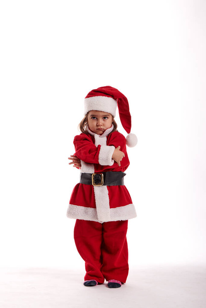 A little girl dressed as Santa Claus on a white background - Фото, зображення