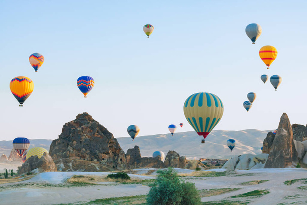 Hot air balloons and fairy chimneys in Cappadocia Turkey. Cappadocia background photo. Hot air balloon activity in Goreme.  - Fotoğraf, Görsel