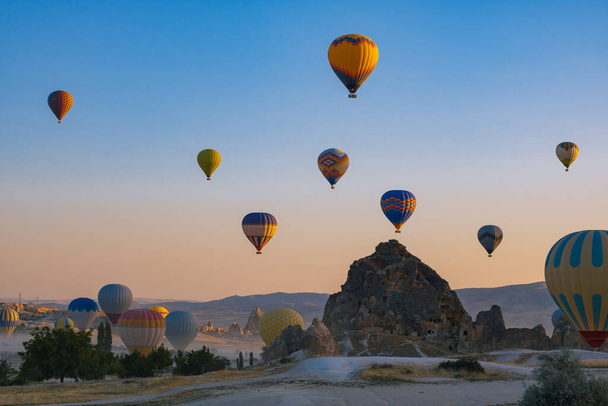 Hot air balloons and fairy chimneys in Cappadocia Turkey. Cappadocia background photo. Hot air balloon activity in Goreme.  - Fotografie, Obrázek