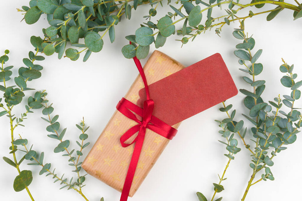 Gift boxes packed in craft paper with simple decor of green plant branches - Fotó, kép
