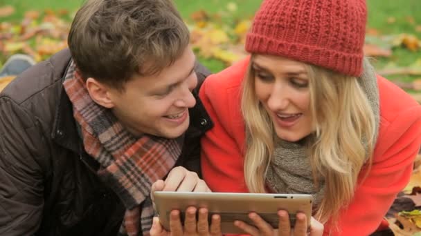 Couple surfing wireless tablet in park - Footage, Video