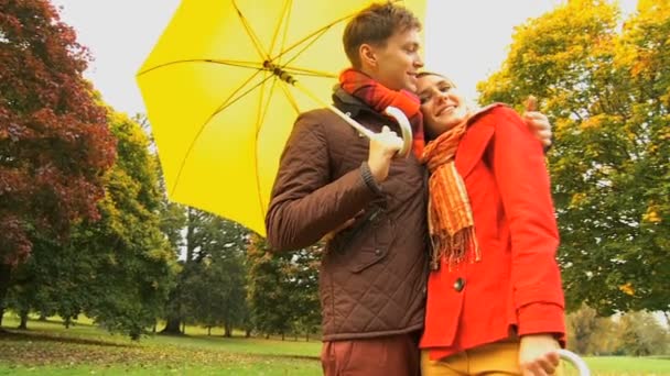 Молодая пара укрывается от погоды в парке
 - Кадры, видео