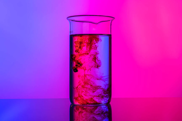 Laboratory glass tubes with chemicals on bright pink background - Foto, immagini