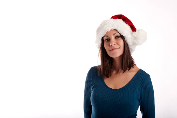 Portrait of a young girl with a Santa Claus hat on a white background - 写真・画像