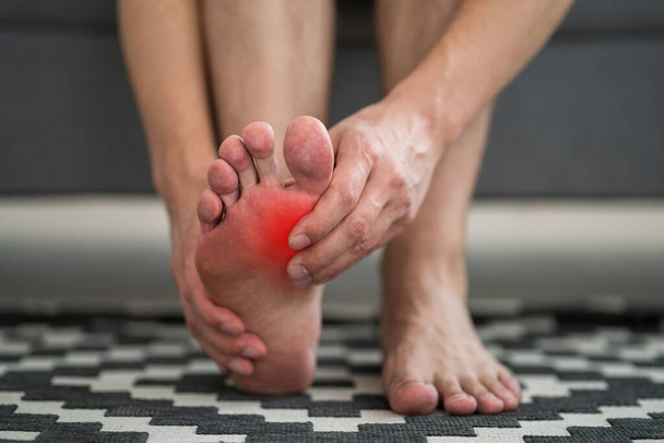Foot pain, man suffering from feet ache at home, podiatry concept - Foto, afbeelding
